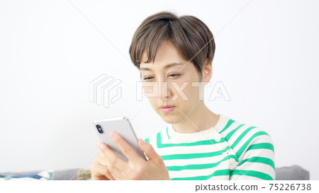 Presbyopia, a woman who squints when she sees a smartphone 75226738