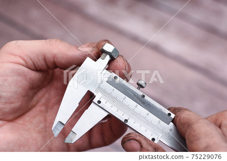 Measuring the diameter of the nut thread with a caliper. Measuring the diameter of the nut thread with a caliper. 75229076