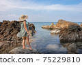 Beautiful woman walking on rock over sea 75229810