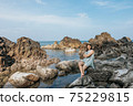 Beautiful woman walking on rock over sea 75229815