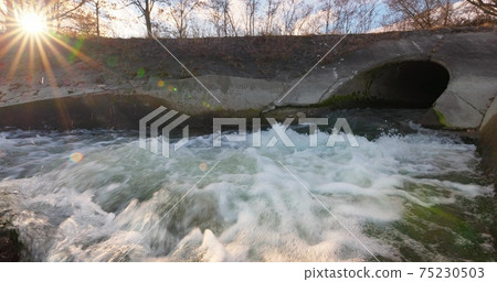 Large sewage tunnel with filth flowing out 75230503