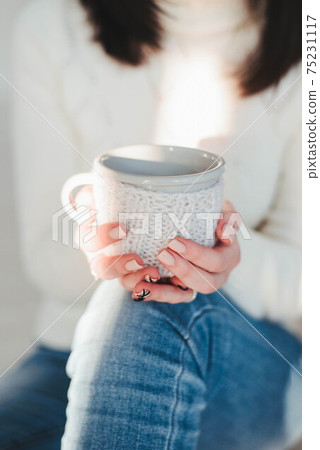 girl holds a white mug in her hands close-up girl holds a white mug in her hands close-up 75231117