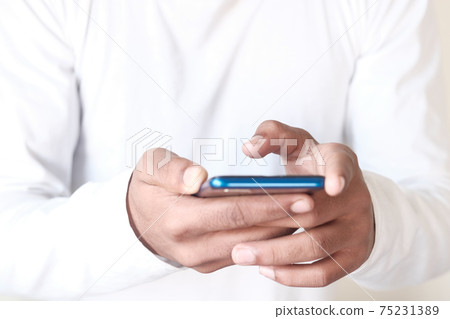 Close up of young man hand using smart phone. Close up of young man hand using smart phone. 75231389