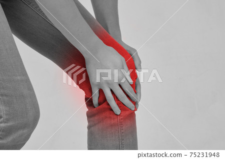 Person massages part of the leg knee due to feeling of pain or injury 75231948