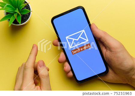 Person sends an email using a smartphone in his hands 75231963