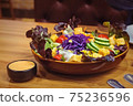 Mixed fresh vegetable salad with sauce on table, clean food concept with selective focus 75236596