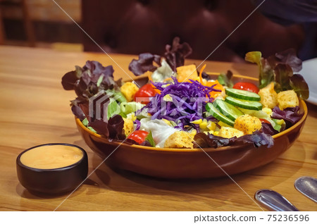 Mixed fresh vegetable salad with sauce on table, clean food concept with selective focus 75236596