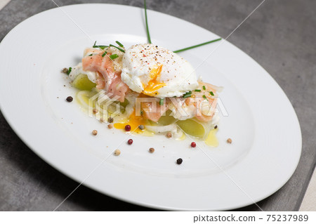 Poached egg on a bed of leek and marinated fresh salmon, chive sauce 75237989