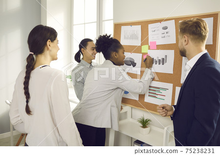 Group of positive international business partnes adding information to marketing data 75238231