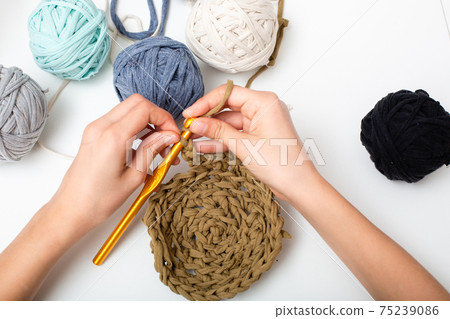 Children's hands are crocheted and thread. View from above Children's hands are crocheted and thread. View from above 75239086