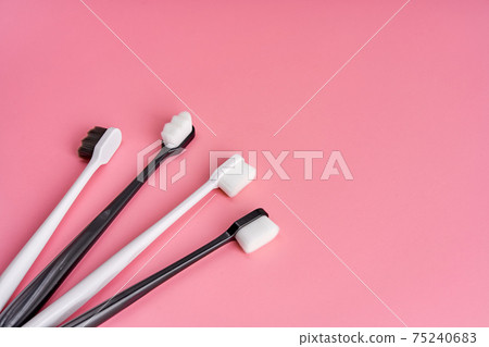 Fashionable toothbrush with soft bristles. Popular toothbrushes. Hygiene trends. Kit of toothbrushes on pink background 75240683