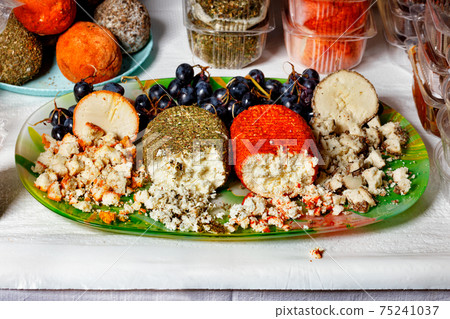 Balls of delicious homemade goat cheese of different varieties on the market counter to sample. Balls of delicious homemade goat cheese of different varieties on the market counter to sample. 75241037