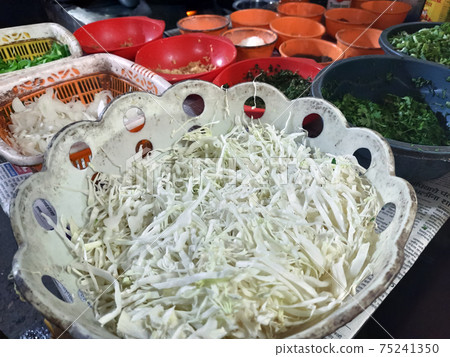 Top view closeup of tomato sauce, lettuce, rice, onions and other appetizers cut in silver bowls Top view closeup of tomato sauce, lettuce, rice, onions and other appetizers cut in silver bowls 75241350