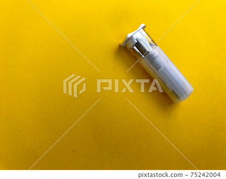 small white lancet on a yellow bright background. finger puncture. medical procedure for health. blood test, assessment of your health small white lancet on a yellow bright background. finger puncture. medical procedure for health. blood test, assessment of your health 75242004
