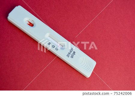test for coronavirus lies on a red background. white test strip on a bright background to determine the infection. sensitive test for coronavirus antibodies test for coronavirus lies on a red background. white test strip on a bright background to determine the infection. sensitive test for coronavirus antibodies 75242006