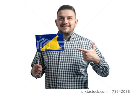 White guy holding a flag of Tokelau and points the finger of the other hand at the flag isolated on a white background White guy holding a flag of Tokelau and points the finger of the other hand at the flag isolated on a white background 75242088