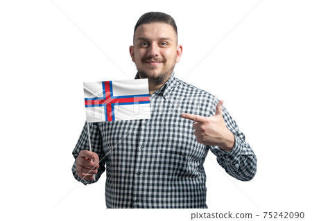 White guy holding a flag of Faroe Islands and points the finger of the other hand at the flag isolated on a white background White guy holding a flag of Faroe Islands and points the finger of the other hand at the flag isolated on a white background 75242090