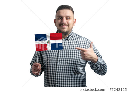 White guy holding a flag of Dominican Republic and points the finger of the other hand at the flag isolated on a white background White guy holding a flag of Dominican Republic and points the finger of the other hand at the flag isolated on a white background 75242125