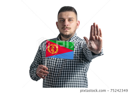 White guy holding a flag of Eritrea and with a serious face shows a hand stop sign isolated on a white background White guy holding a flag of Eritrea and with a serious face shows a hand stop sign isolated on a white background 75242349