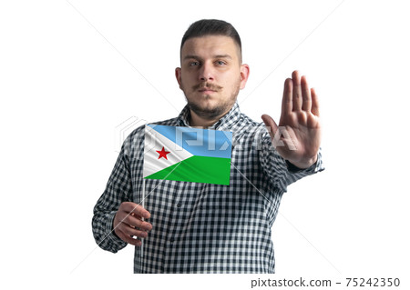White guy holding a flag of Djibouti and with a serious face shows a hand stop sign isolated on a white background White guy holding a flag of Djibouti and with a serious face shows a hand stop sign isolated on a white background 75242350