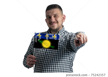 White guy holding a flag of Guadeloupe and points forward in front of him isolated on a white background White guy holding a flag of Guadeloupe and points forward in front of him isolated on a white background 75242357