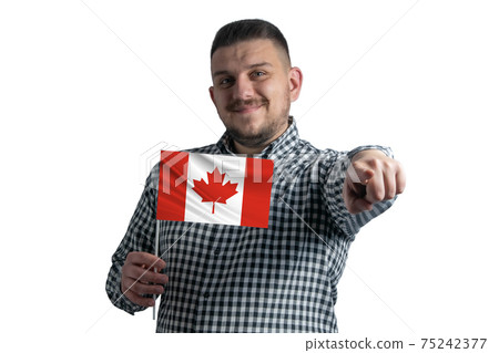 White guy holding a flag of Canada and points forward in front of him isolated on a white background 75242377