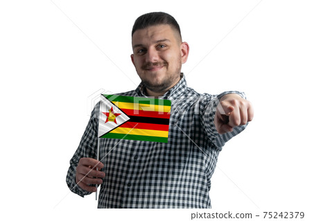 White guy holding a flag of Zimbabwe and points forward in front of him isolated on a white background 75242379