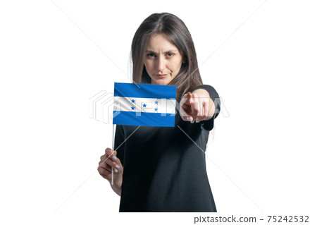 Happy young white woman holding flag of Honduras and points forward in front of him isolated on a white background Happy young white woman holding flag of Honduras and points forward in front of him isolated on a white background 75242532