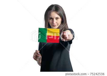 Happy young white woman holding flag of Benin and points forward in front of him isolated on a white background Happy young white woman holding flag of Benin and points forward in front of him isolated on a white background 75242536