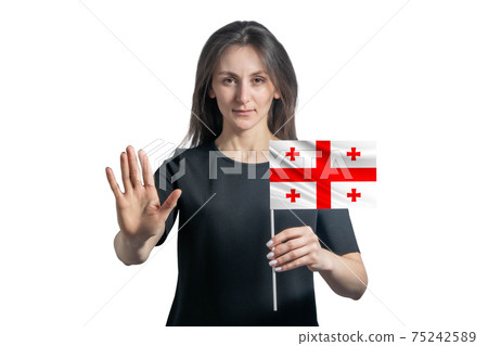 Happy young white woman holding flag of Georgia and with a serious face shows a hand stop sign isolated on a white background Happy young white woman holding flag of Georgia and with a serious face shows a hand stop sign isolated on a white background 75242589