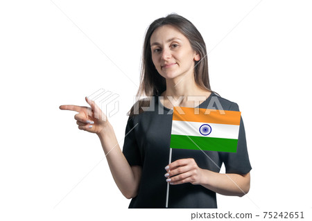Happy young white woman holding flag India and points to the left isolated on a white background 75242651