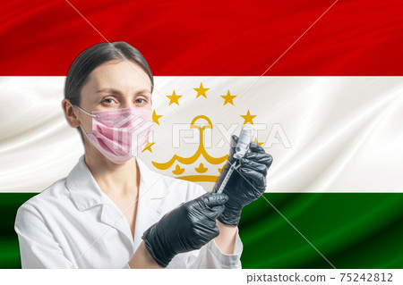 Girl doctor prepares vaccination against the background of the Tajikistan flag. Vaccination concept Tajikistan Girl doctor prepares vaccination against the background of the Tajikistan flag. Vaccination concept Tajikistan 75242812