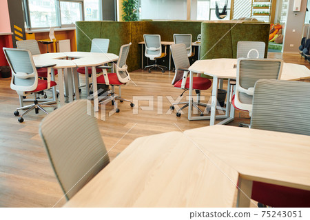 Interior of large open space office with many chairs by various kinds of tables Interior of large open space office with many chairs by various kinds of tables 75243051