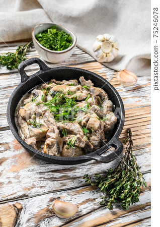 Beef stroganoff with mushrooms in frying pan. White background. Top view Beef stroganoff with mushrooms in frying pan. White background. Top view 75246078