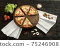 Delicious pizza on a wooden cutting board 75246908