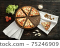 Delicious pizza on a wooden cutting board 75246909