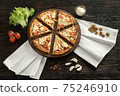 Delicious pizza on a wooden cutting board 75246910