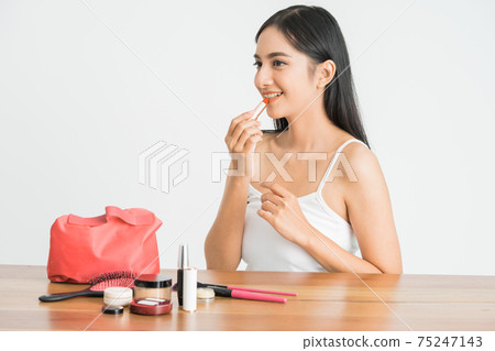 attractive beautiful mixed race asian woman applying lipstick on her lips 75247143