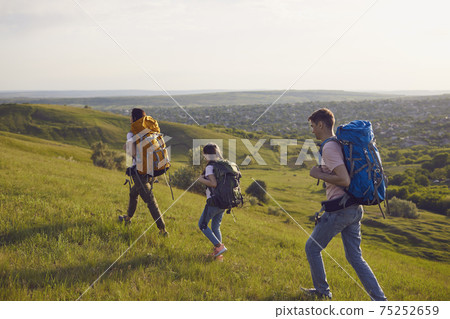 Happy trip family hikers with backpacks is walking in nature. Camping in the nature. Happy trip family hikers with backpacks is walking in nature. Camping in the nature. 75252659