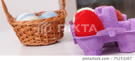 Easter eggs in wicker basket and cardboard box. Festive time and decoration 75253267