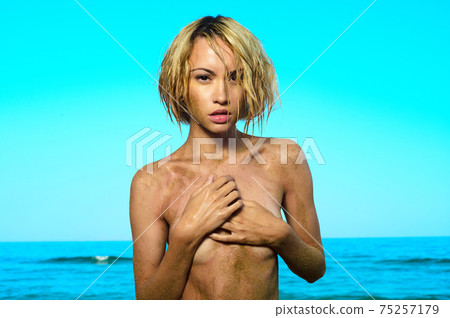 Beautiful nude woman with nice tan on the beach 75257179