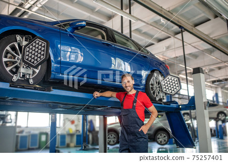 Smiling repairman standing posing near auto 75257401