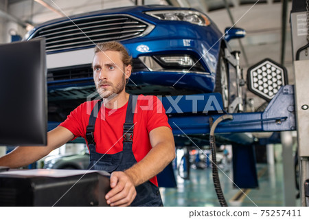 Concentrated man at computer in body shop Concentrated man at computer in body shop 75257411