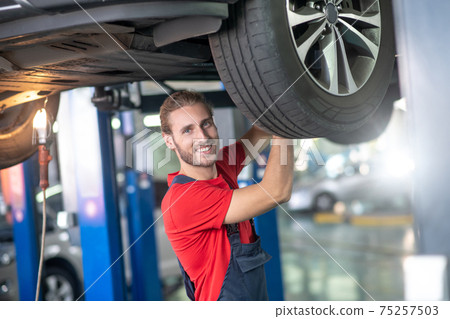 Happy man working in auto workshop Happy man working in auto workshop 75257503