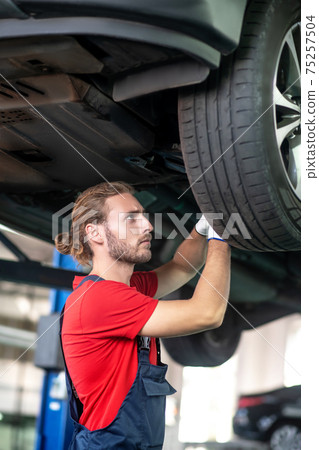 Involved male repairman in profile near the car 75257504
