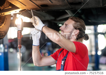 Smiling male auto mechanic in garage 75257516