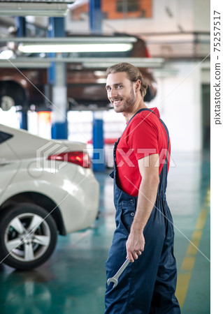 Man with wrench at an auto service station Man with wrench at an auto service station 75257517