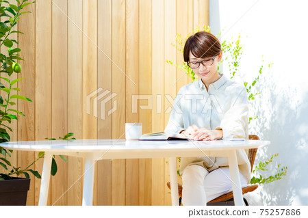 戴著眼鏡在露台上看書的中年女人 75257886
