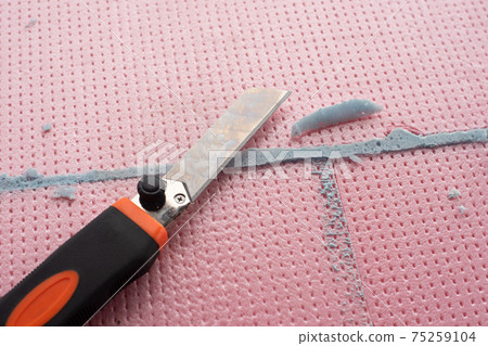 the master with a knife cuts off excess construction foam the master with a knife cuts off excess construction foam 75259104