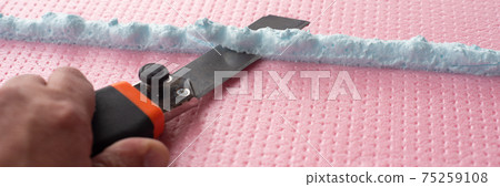 the master with a knife cuts off excess construction foam the master with a knife cuts off excess construction foam 75259108